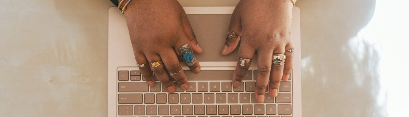 woman's hands typing on a laptop keyboard