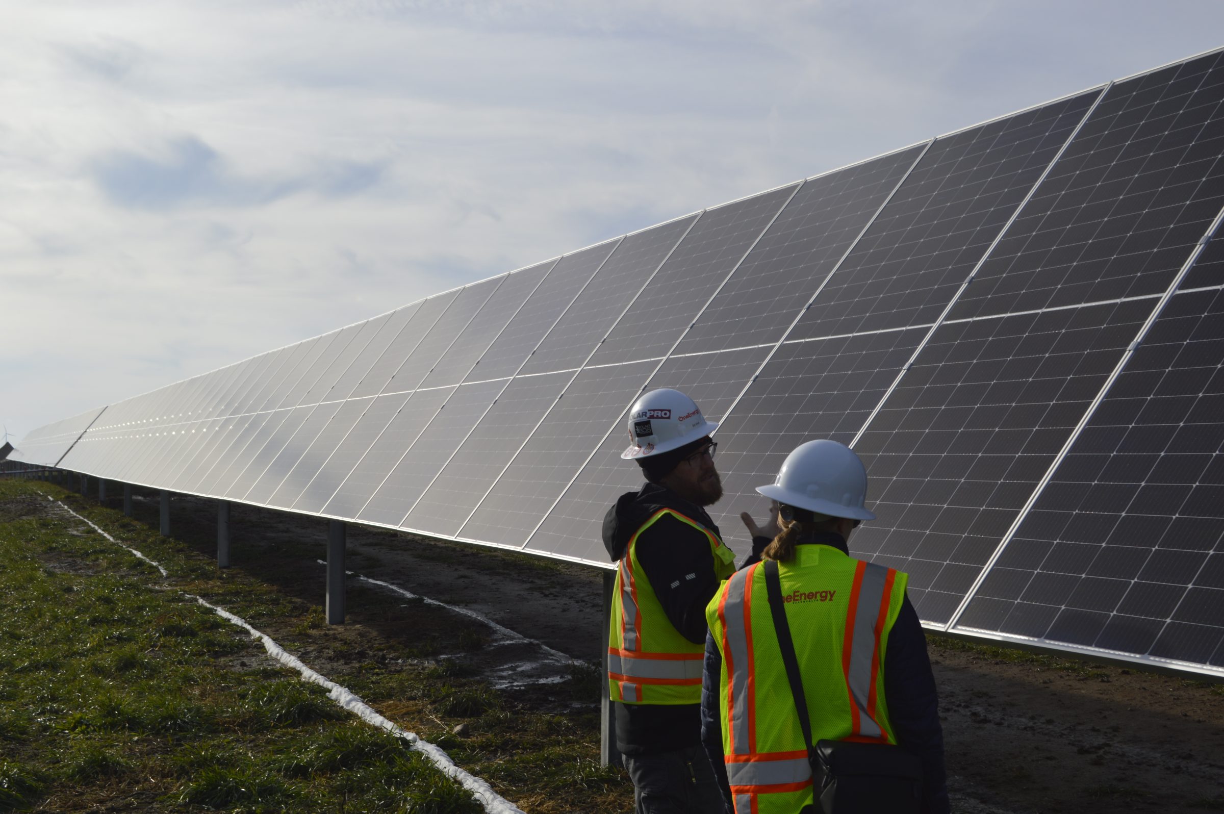 Construction workers next to solar panels