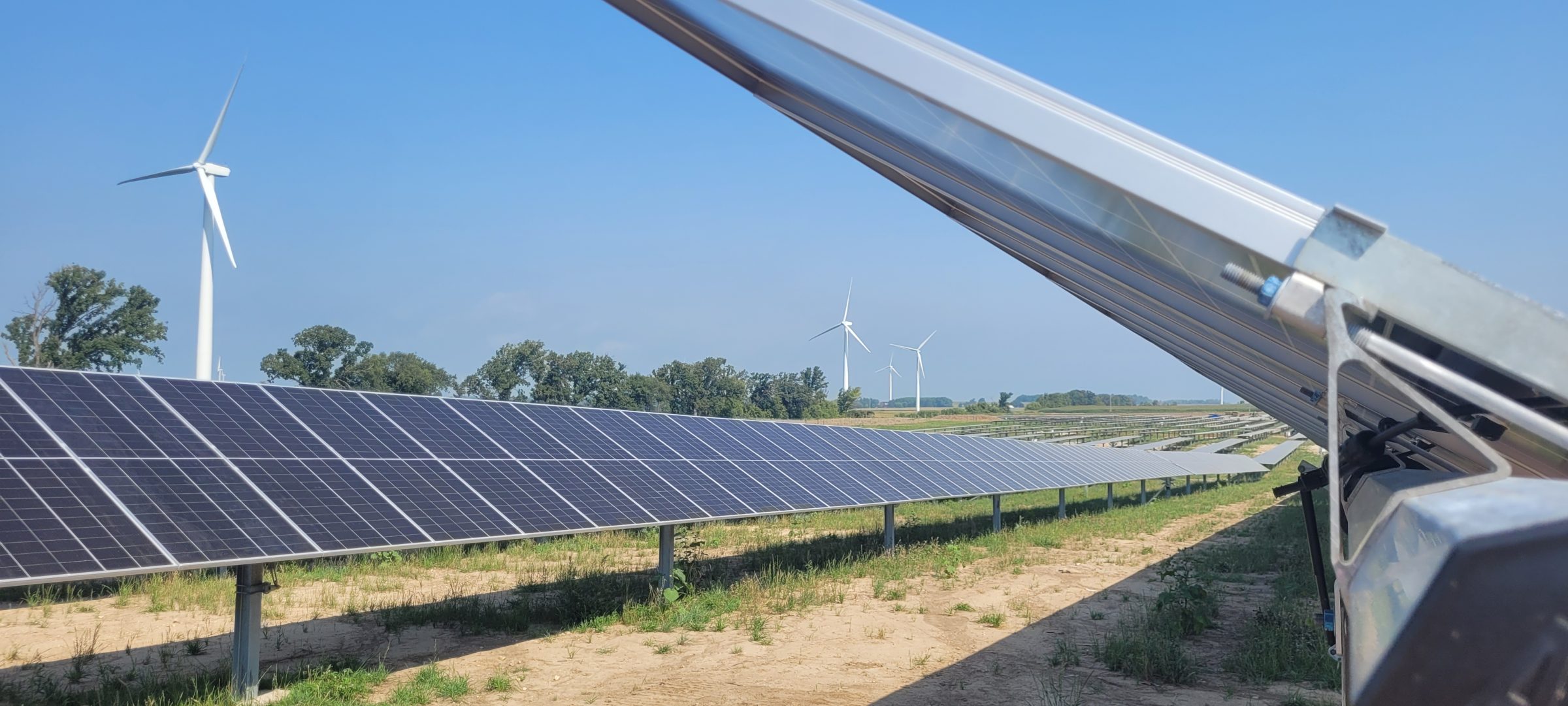 windmills and solar panels in a field 